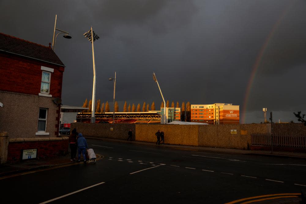 Golden light hits the ground as a rainbow forms after the match with Salford