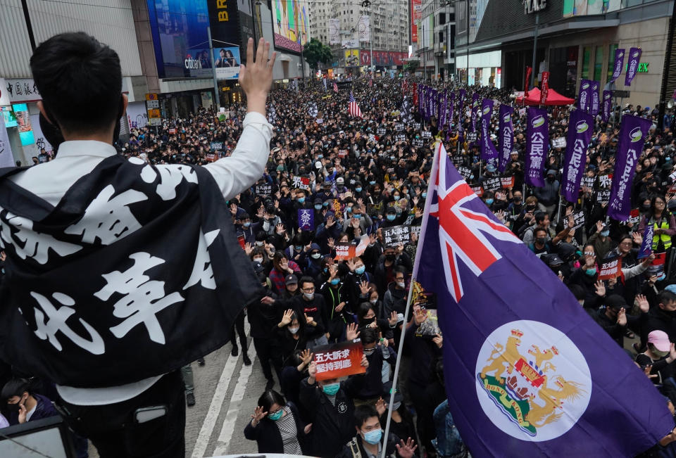 FILE - A man waves Hong Kong's colonial flag as people participate in their annual pro-democracy march on New Year's Day to insist their five demands be matched by the government in Hong Kong, Wednesday, Jan. 1, 2020. Hong Kong leader Carrie Lam on Monday said Chinese patriots are now firmly in charge of the city following the election of its new leader, who ran unopposed in a process controlled by Beijing from start to finish. (AP Photo/Vincent Yu, file)