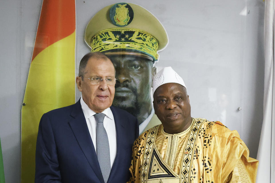 In this photo released by Russian Foreign Ministry Press Service, Russian Foreign Minister Sergey Lavrov, left, and Guinea's foreign minister Morissanda Kouyate pose for a photo near a portrait of Guinea's President Mamadi Doumbouya during their meeting in Conakry, Guinea, Monday, June 3, 2024. Russian Foreign Minister Sergey Lavrov arrived Monday in Guinea on his latest visit to West Africa, where coups and growing discontent with traditional allies like France and the United States have contributed to some countries' shift towards Moscow. (Russian Foreign Ministry Press Service via AP)