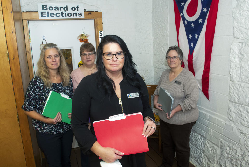 Carroll County Election Director Nicole Mickley, front, stands with clerk Deloris Kean, left, Deputy Director Cheri Whipkey, center and clerk Sarah Dyck at the Carroll County Board of Elections in Carrollton, Ohio Monday, Sept. 26, 2022. (AP Photo/Phil Long)