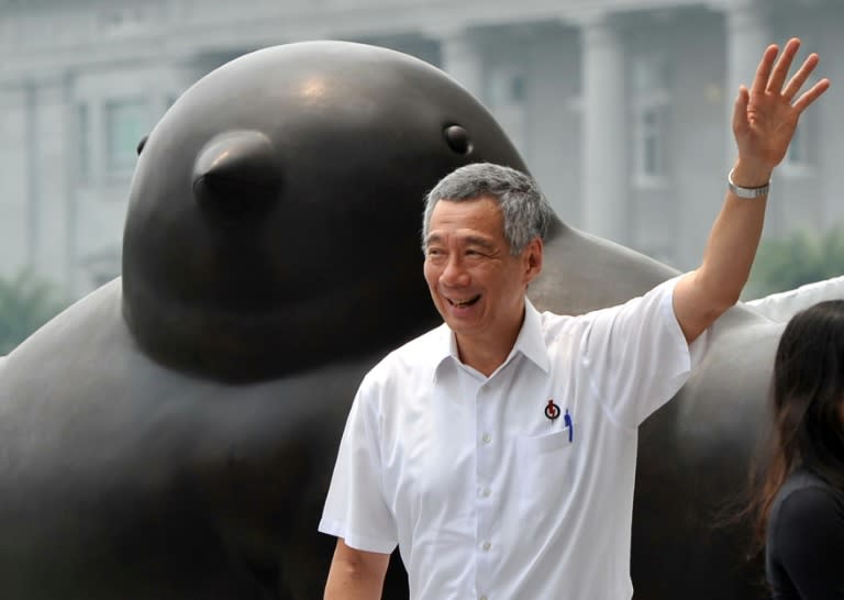 Singapore's Prime Minister Lee Hsien Loong, from the ruling People's Action Party, greets the crowd during a lunch time rally in Raffles Place on September 8, 2015 ahead of Singapore's September 11 election