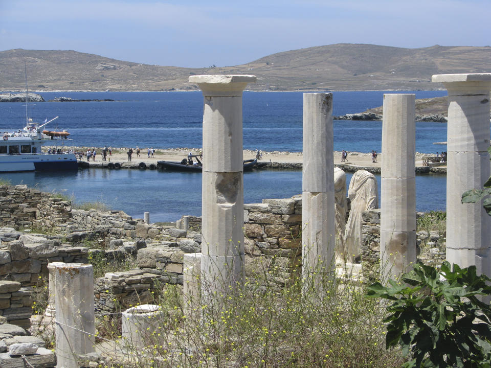 Ancient statues and columns from a millennia-old house stand just above the landing dock in the archaeological park at Delos, Greece, on May 25, 2019. The tiny island, a short boat ride from party-central Mykonos, was considered holy by ancient Greeks. (AP Photo/Giovanna Dell’Orto)