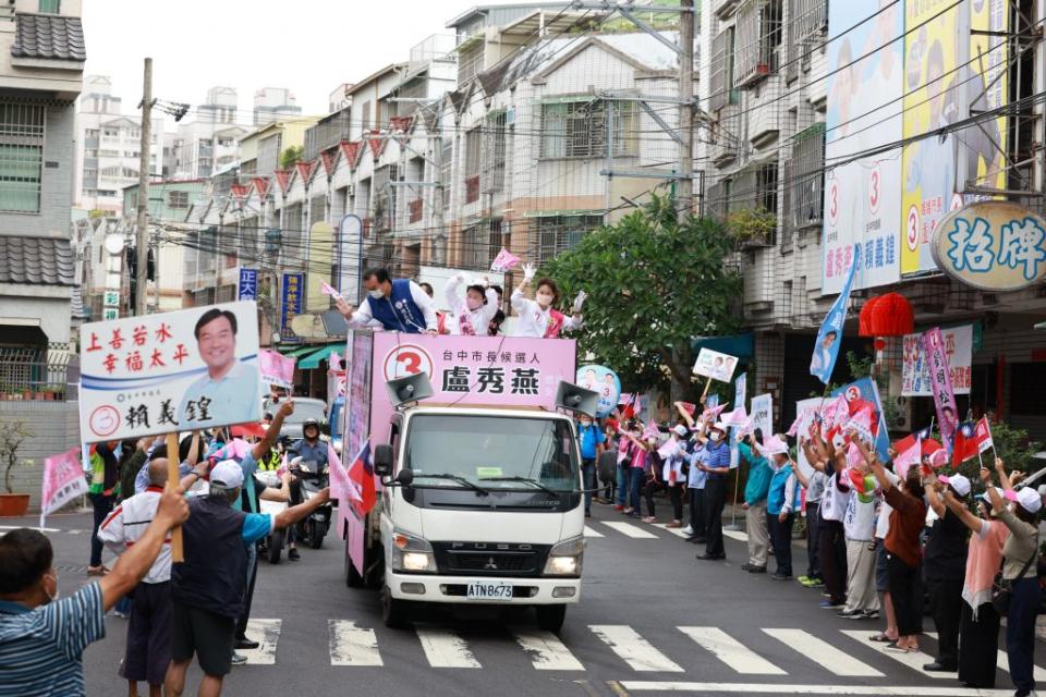 盧秀燕穿著雨衣在大雨中誠懇拜託，遇到支持者熱情揮手或手比三號OK手勢，盧秀燕用雙手比一個大大的愛心溫暖回應。（記者徐義雄攝）