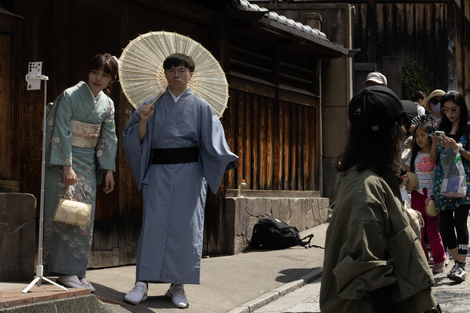 Kimono-clad visitors take a selfie photograph in Kyoto, Japan, on Saturday, April 13, 2024. (Photographer: Buddhika Weerasinghe/Bloomberg)