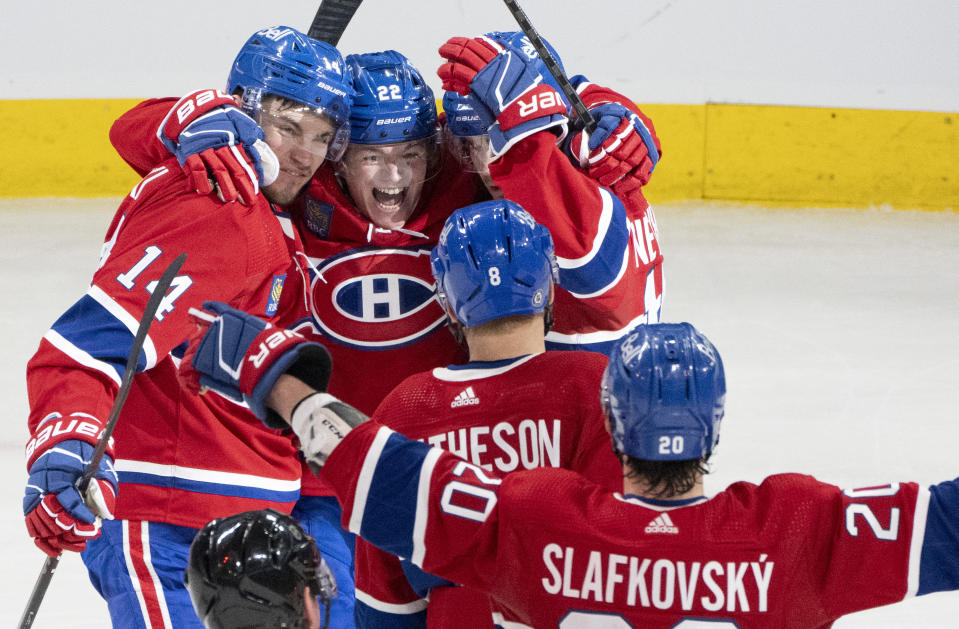 Montreal Canadiens' Nick Suzuki (14) celebrates his second goal against the Anaheim Ducks with Cole Caufield (22), Mike Matheson (8), Alex Newhook (15) and Juraj Slafkovsky (20), during the second period of an NHL hockey game Tuesday, Feb. 13, 2024, in Montreal. (Christinne Muschi/The Canadian Press via AP)