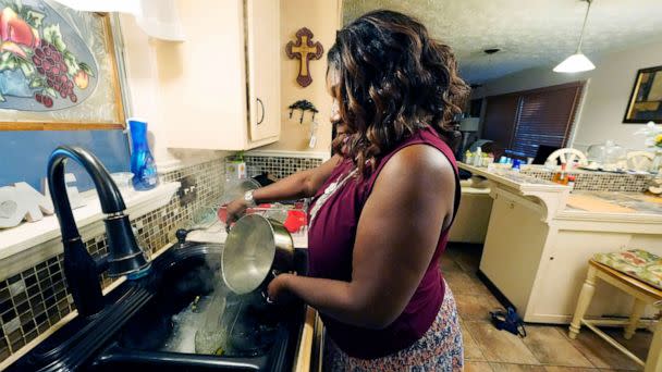 PHOTO: Bennie Hudson pours boiling water into her sink before washing dishes at her Jackson, Miss., Sept. 1, 2022. (Rogelio V. Solis/AP)