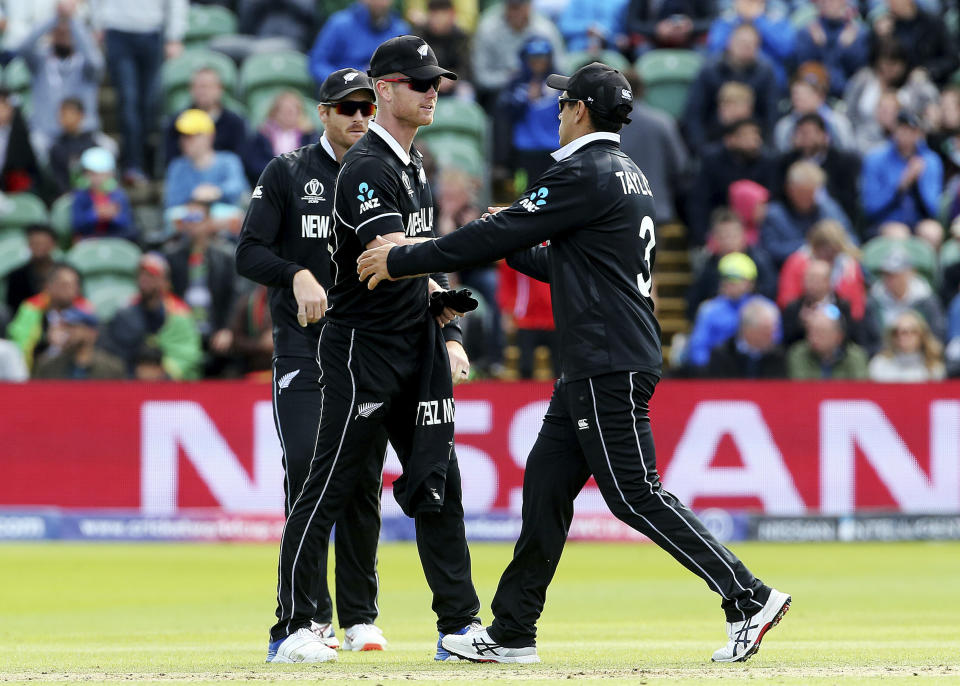 New Zealand's James Neesham, left, finishes his ten overs of bowling, 5 wickets for 31 runs, and shakes hands with Ross Taylor during the ICC Cricket World Cup group stage match between Afghanistan and New Zeland, at the County Ground Taunton, England, Saturday, June 8, 2019. (Mark Kerton/PA via AP)