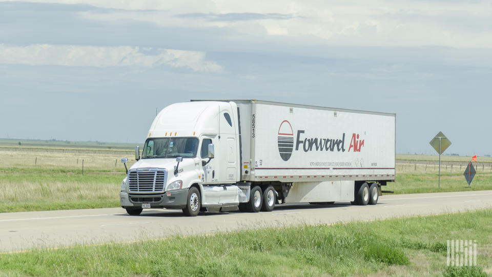 A white tractor pulling a Forward Air trailer on a highway