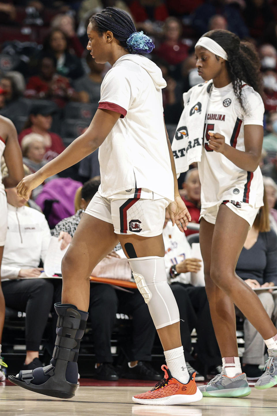 South Carolina forward Aliyah Boston, left, walks to the bench with her right foot in a boot after being injured in the first half of an NCAA college basketball game against Hampton in Columbia, S.C., Sunday, Nov. 27, 2022. South Carolina won 85-38. (AP Photo/Nell Redmond)