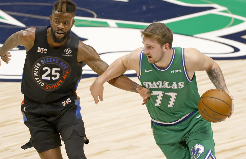 Dallas Mavericks guard Luka Doncic (77) is defended by New York Knicks forward Reggie Bullock (25) during the first half of an NBA basketball game Friday, April 16, 2021, in Dallas. (AP Photo/Ron Jenkins)