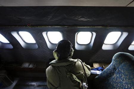 A crew member from the Royal Malaysian Air Force looks through the window of a Malaysian Air Force CN235 aircraft during a Search and Rescue (SAR) operation to find the missing Malaysia Airlines flight MH370, in the Straits of Malacca March 13, 2014. REUTERS/Samsul Said