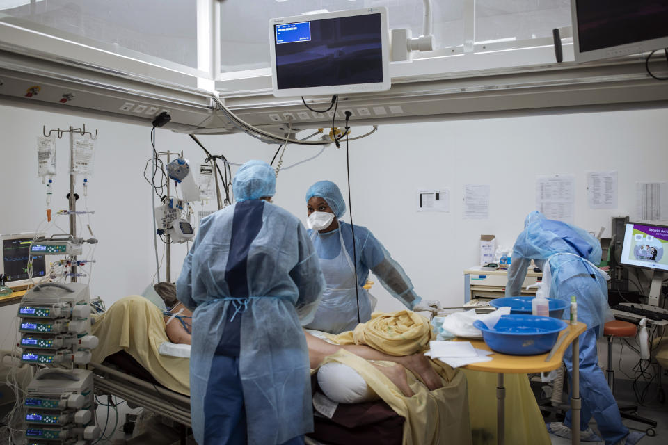 Nurse Yevana Faro, center, cares for a patient inside an operating room now used for unconscious COVID-19 patients at Bichat Hospital, AP-HP, in Paris, Thursday, April 22, 2021. France still had nearly 6,000 critically ill patients in ICUs this week as the government embarked on the perilous process of gingerly easing the country out of its latest lockdown, too prematurely for those on pandemic frontlines in hospitals. President Emmanuel Macron's decision to reopen elementary schools on Monday and allow people to move about more freely again in May, even though ICU numbers have remained stubbornly higher than at any point since the pandemic's catastrophic first wave, marks another shift in multiple European capitals away from prioritizing hospitals. (AP Photo/Lewis Joly)