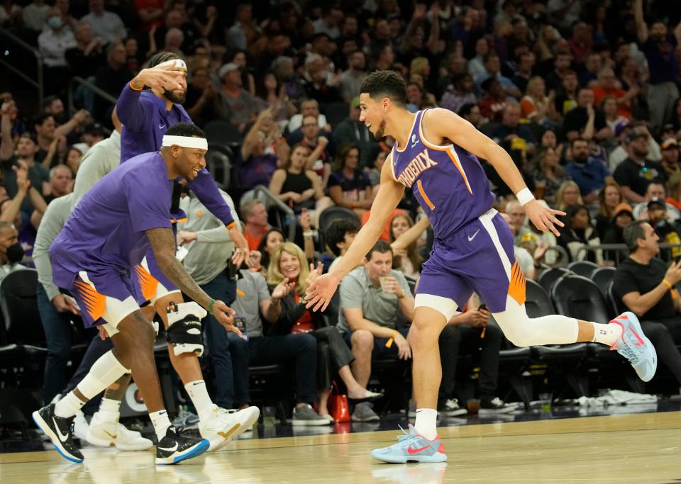 Phoenix Suns guard Devin Booker (1) celebrates with forward Torrey Craig (0) after a three-point basket against the Los Angeles Lakers during the third quarter at Footprint Center.