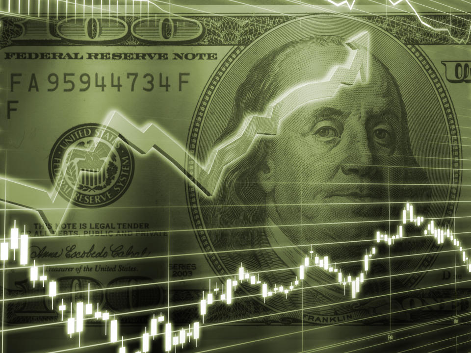 Two stock chart lines superimposed on an image of a one-hundred-dollar bill