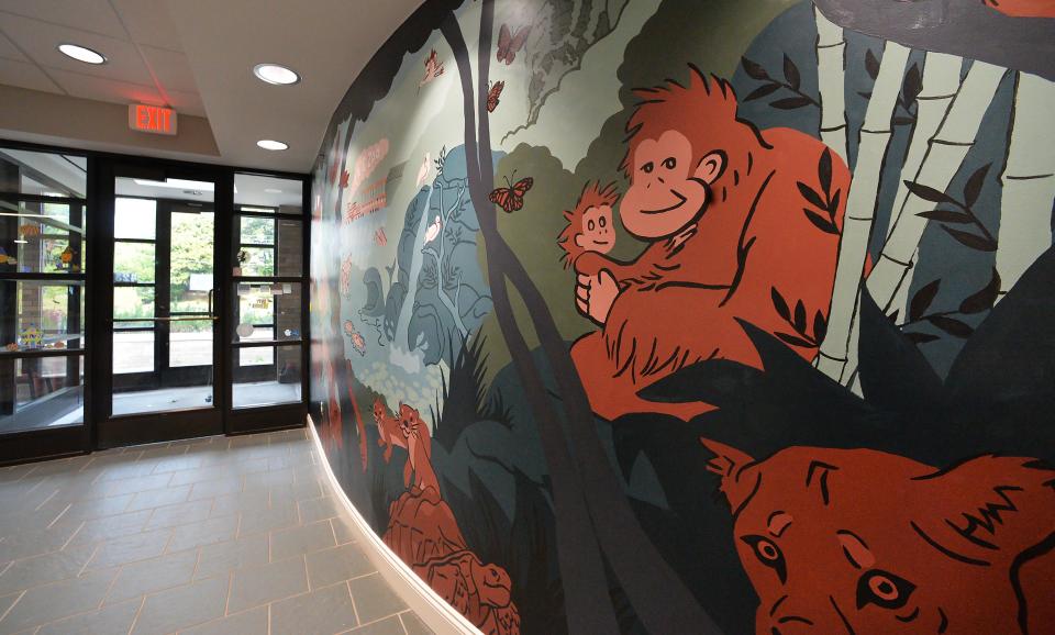 A newly-painted mural, by artist Alex Strasser, is shown at the Erie Zoo near offices repaired after extensive water damage to the building last year.