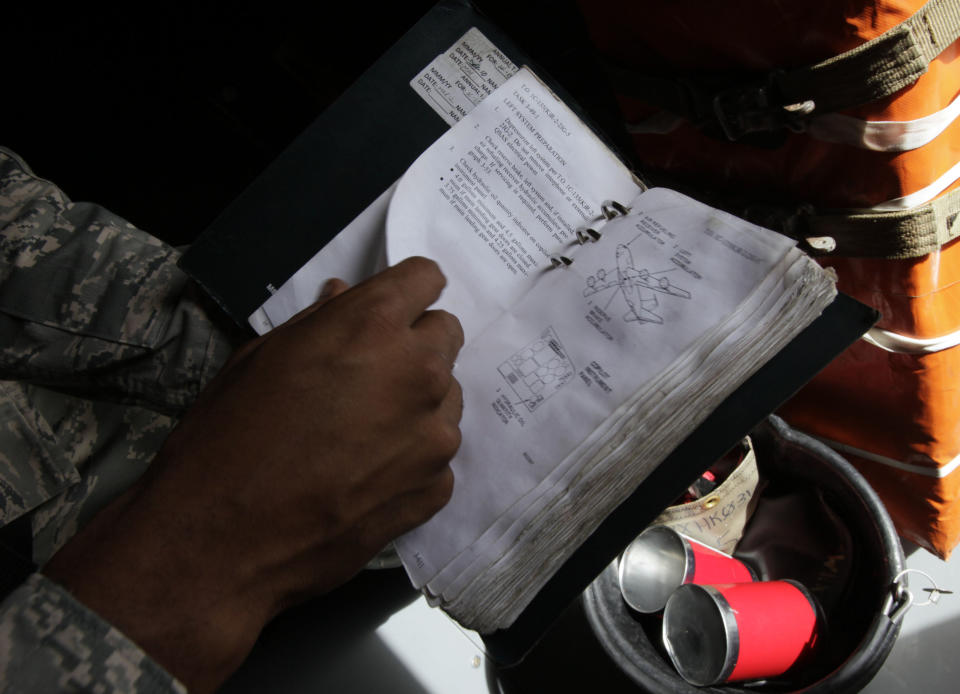 In this Aug. 14, 2012 photo, a ground crew member looks at a service manual in a U.S. Air Force KC-135 Stratotanker, which was built in 1958, at Kadena Air Base on Japan's southwestern island of Okinawa. For decades, the U.S. Air Force has grown accustomed to such superlatives as unrivaled and unbeatable. Now some of its key aircraft are being described with terms like decrepit. (AP Photo/Greg Baker)