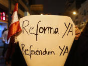 A demonstrator holds a sign that reads: 'Reform now, Referendum now' during a protest to support Peru's President Martin Vizcarra after he asked the Congress for a new vote of confidence in his Cabinet in Lima, Peru September 18, 2018. REUTERS/Guadalupe Pardo