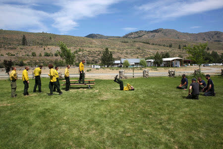 Instructors (R) watch a rookie class of eight smokejumper recruits as they practise parachute landing fall techniques at the North Cascades Smokejumper Base in Winthrop, Washington, U.S., June 7, 2016. REUTERS/David Ryder