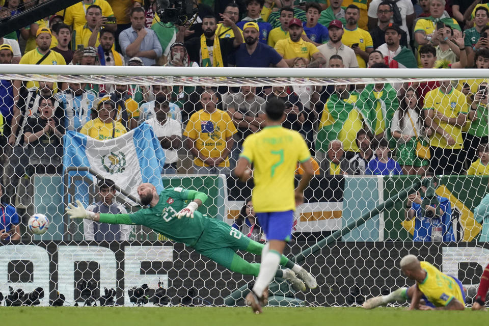 Serbia's goalkeeper Vanja Milinkovic-Savic, left, dives but fails to save the goal from Brazil's Richarlison, right, during the World Cup group G soccer match between Brazil and Serbia, at the Lusail Stadium in Lusail, Qatar, Thursday, Nov. 24, 2022. (AP Photo/Natacha Pisarenko)