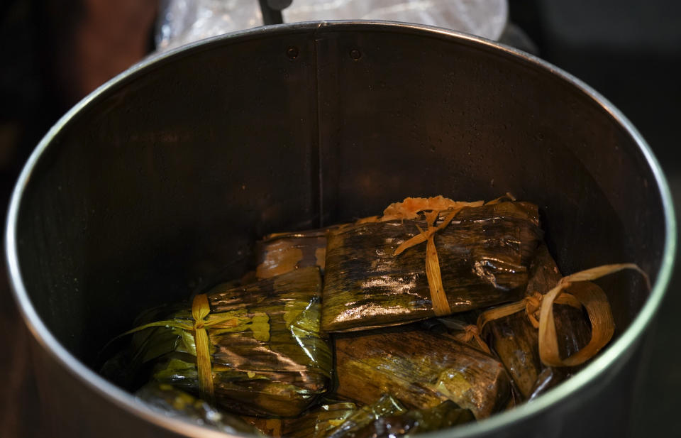 A pot full of Oaxaca style tamales waits for customers at a street stand in Mexico City, Thursday, Jan. 26, 2023. Vendors set up stands across the city before dawn at subway stops and street corners where tamales steam in giant pots fired by gas burners or charcoal. (AP Photo/Fernando Llano)