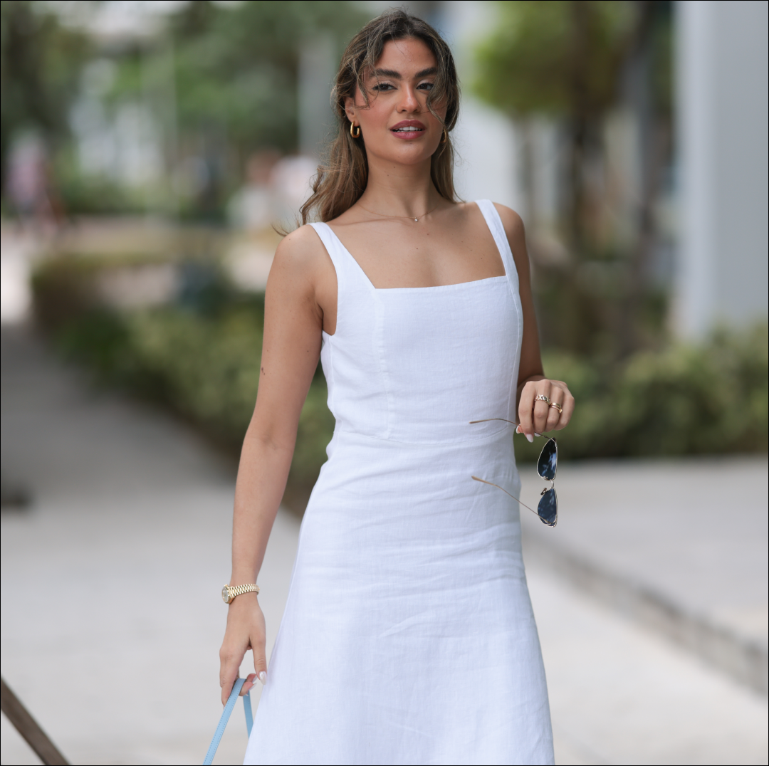  Jessica De Oliveira seen wearing gold earrings, Riani white strappy long dress, Jacquemus light blue suede leather Bambino Long bag, Dior gold cat-eye sunglasses, on December 09, 2023 in Miami, Florida. . 