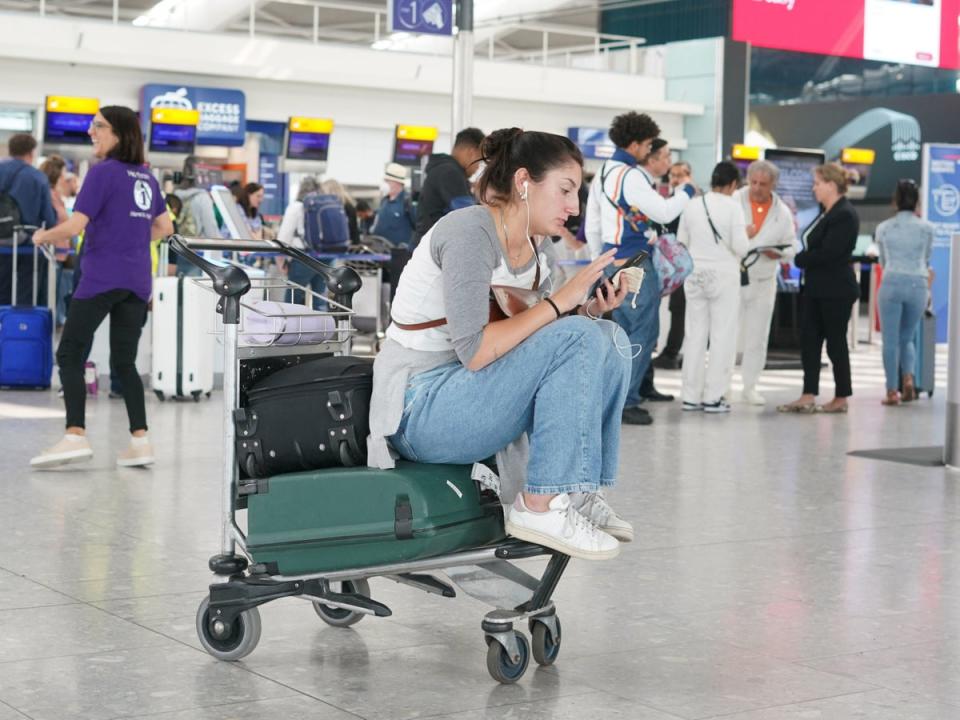 A traveller waits for flight information at Heathrow on Tuesday (PA)