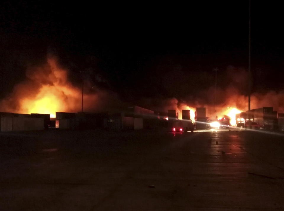 In this photo released by the Syrian official news agency SANA, flames rise from containers at the scene of missiles attack, at the seaport of the coastal city of Latakia, Syria, early Tuesday, Dec. 28, 2021. Israeli missiles fired from the Mediterranean struck the Syrian port of Latakia early Tuesday, igniting a fire in the container terminal, Syrian state media reported, in the second such attack on the vital facility this month. (SANA via AP)