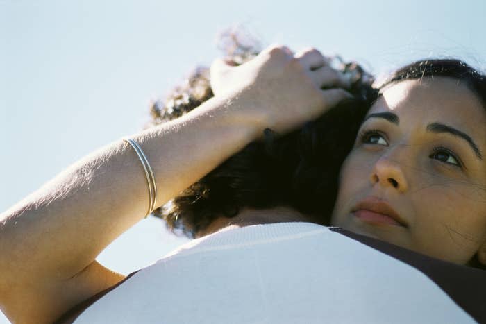 Two people embracing, one resting their head on the other's shoulder, both appearing content