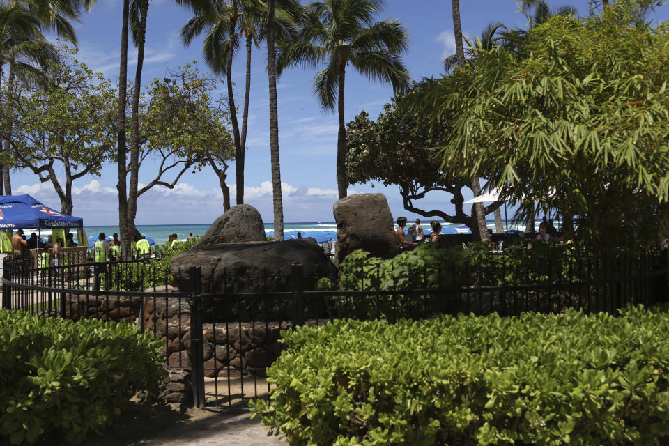 The Kapaemahu stones are seen at Waikiki beach in Honolulu on Tuesday, June 28, 2022. A new exhibit at Honolulu's Bishop Museum draws attention to the stones which honor four "mahu" healers from Tahiti who visited Hawaii more than five centuries. (AP Photo/Audrey McAvoy)