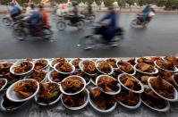 <p>Commuters travel past plates of food placed for passersby to break their fast during Ramadan in Karachi, Pakistan, May 29, 2017. (Akhtar Soomro/Reuters) </p>