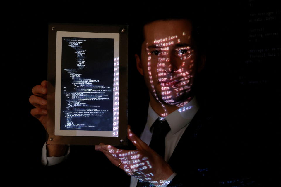 Aguttes auction house head of development Maximilien Aguttes holds a non-fungible token (NFT), replica of the original communication protocol that transmitted the first SMS text message ever sent, before its auction by Britain&#39;s Vodafone, in Neuilly-sur-Seine, near Paris, France, December 20, 2021.  REUTERS/Christian Hartmann