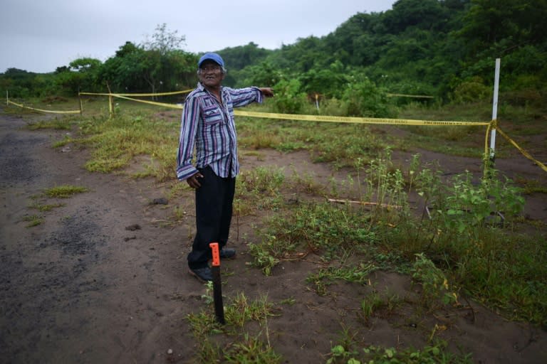 Guadalupe Contreras, member of the search brigade 'Solecito' points at the site where a clandestine grave was found one year ago, in Colinas de Santa Fe, Mexico's Veracruz state