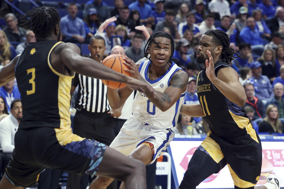 Kentucky's Rob Dillingham, middle, drives between Texas A&M-Commerce's Tommie Lewis (3) and Khaliq Abdul-Mateen (11) during the first half of an NCAA college basketball game in Lexington, Ky., Friday, Nov. 10, 2023. (AP Photo/James Crisp)