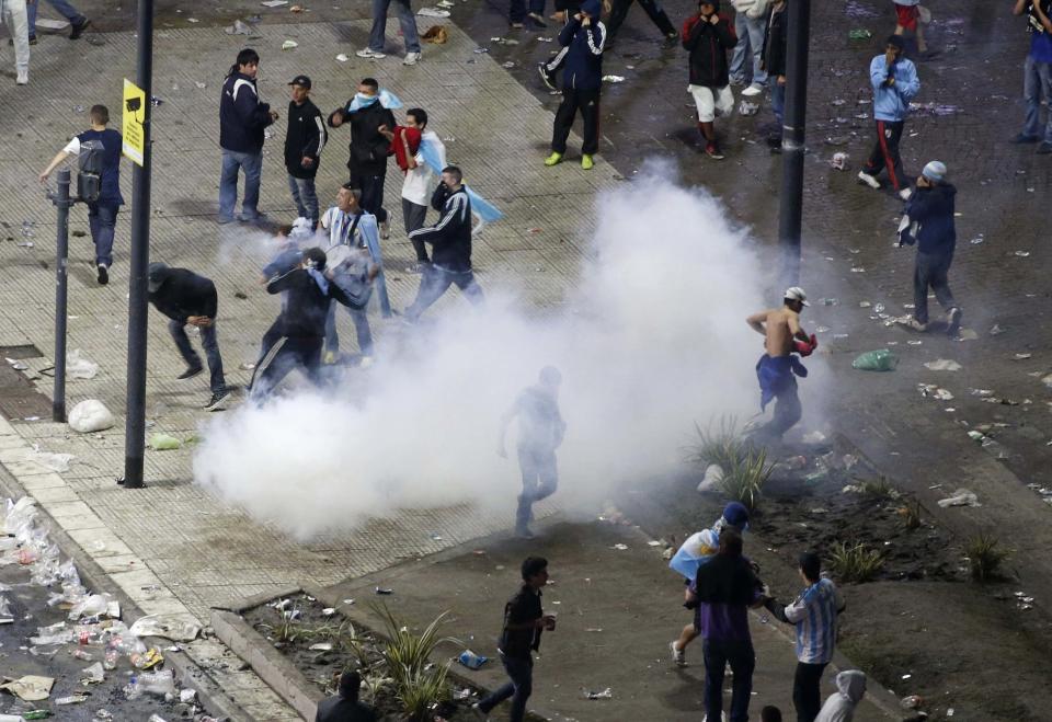 Argentina's fans run from police firing tear gas after Argentina lost to Germany in their 2014 World Cup final soccer match in Brazil, at a public square viewing area in Buenos Aires, July 13, 2014. (REUTERS/Andres Stapff)