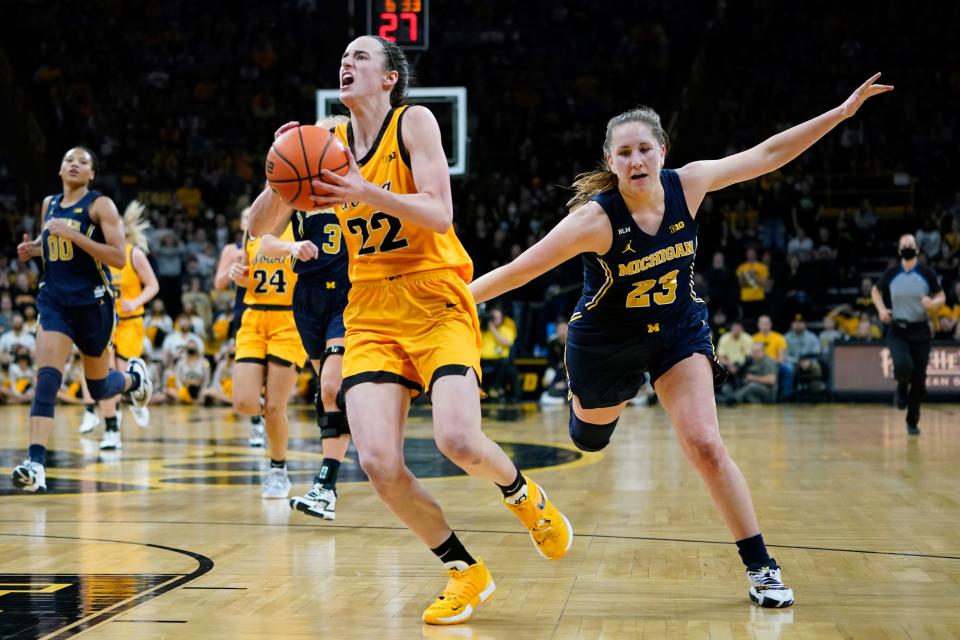 Iowa guard Caitlin Clark (22) drives to the basket ahead of Michigan guard Danielle Rauch (23) during their game  Sunday, Feb. 27, 2022, in Iowa City, Iowa.