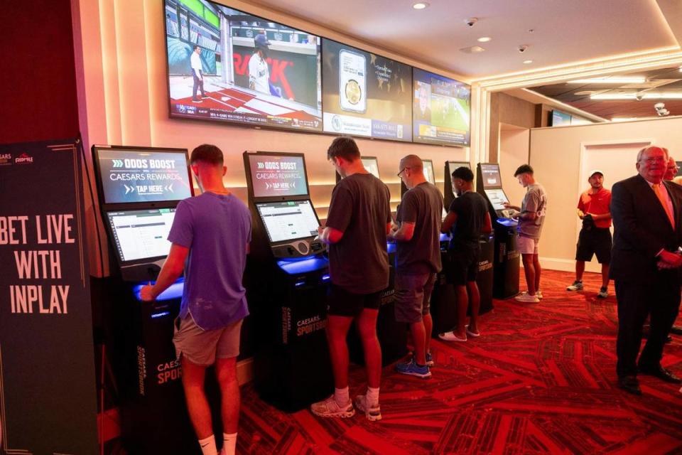 Patrons place bets at the opening of a Caesars Sportsbook at Red Mile on Sept. 7.