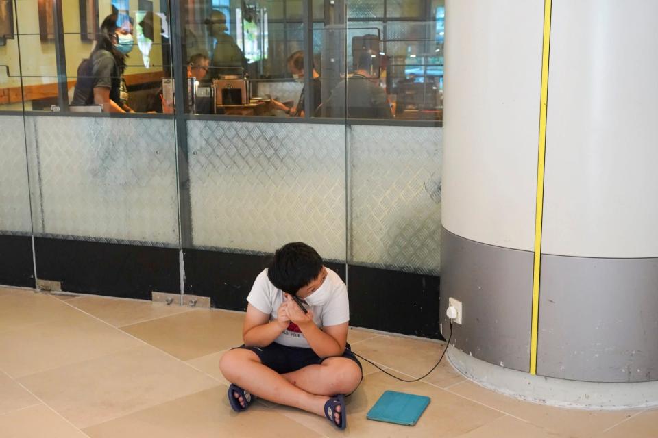 A resident in Tin Shui Wai charges his mobile phone in a shopping centre. Photo: Felix Wong