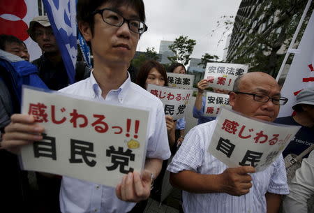 Protesters hold placards during a rally against Japan's Prime Minister Shinzo Abe's administration and his security-related legislation in front of the parliament building in Tokyo July 16, 2015. REUTERS/Issei Kato