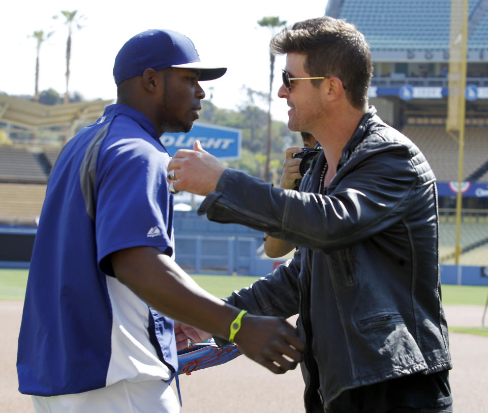 Los Angeles Dodgers' Yasiel Puig, left, meets musician Robin Thicke, who will sing in a concert prior to a baseball game against the San Francisco Giants on Saturday, April 5, 2014, in Los Angeles. (AP Photo/Alex Gallardo)