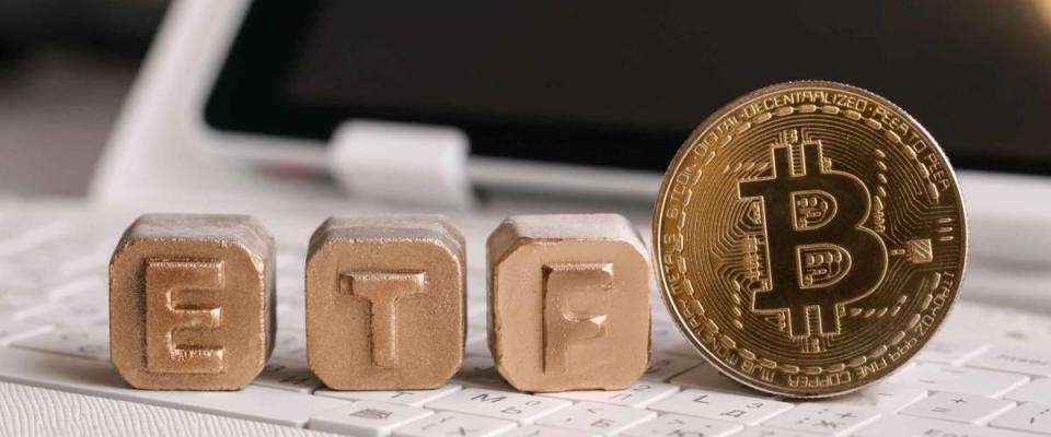 letters Gold ETF and Bitcoin on white keyboard