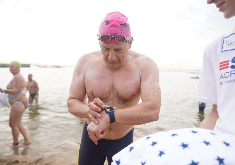 Mike Kelly from Larchmont checks the time in his watch as he emerges from the water as over 500 swimmers take part in Swim Across America open water swim in Larchmont to raise funds for cancer research, clinical trials and client services on Saturday, July 29, 2023.