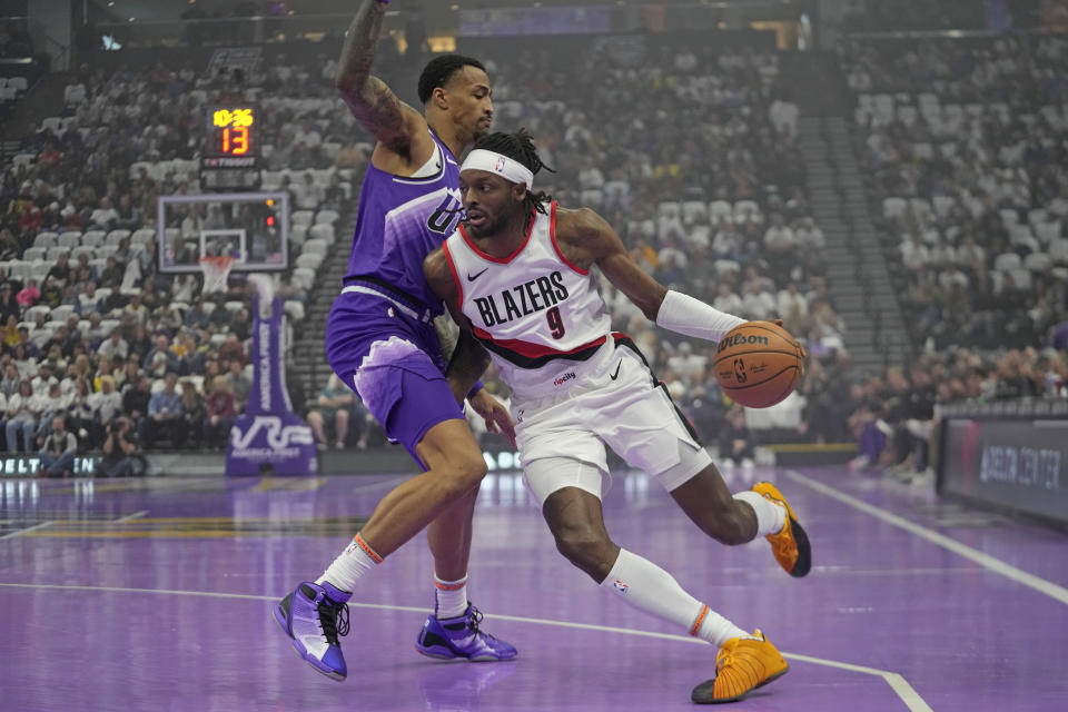 Utah Jazz forward John Collins, left, defends against Portland Trail Blazers forward Jerami Grant (9) as he drives during the first half of an NBA basketball in-season tournament game, Tuesday, Nov. 14, 2023, in Salt Lake City. (AP Photo/Rick Bowmer)