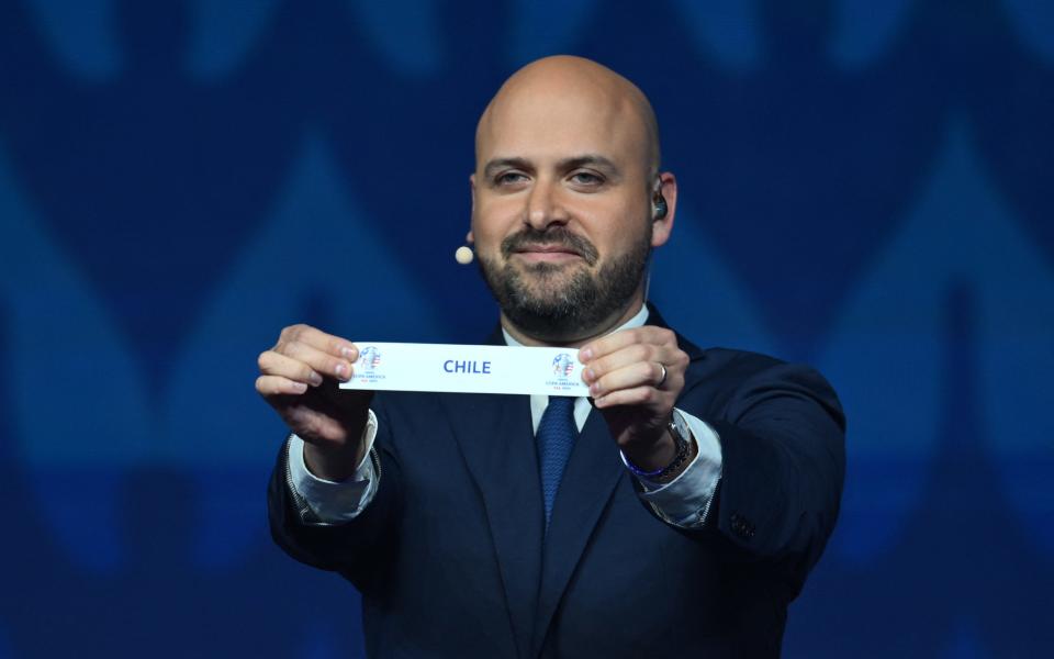CONCACAF's Chief Football Competitions Officer Carlos Fernandez holds up a slip of paper after drawing the Chile from the pot during the final draw for the Conmebol Copa America 2024 football competition at the James L. Knight Centre in Miami, Florida, on December 7.