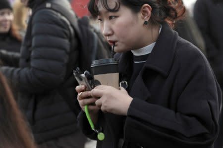 FILE PHOTO: A woman drinks from a paper cup through a plastic straw on Westminster Bridge in London, Britain January 6, 2018. REUTERS/Simon Dawson