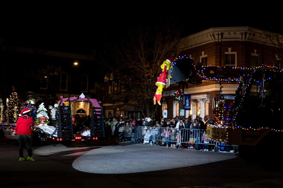 An inflatable grinch hangs off of construction equipment during the annual Christmas parade and tree lighting in downtown Columbia, Tenn. on Dec. 3, 2022. 