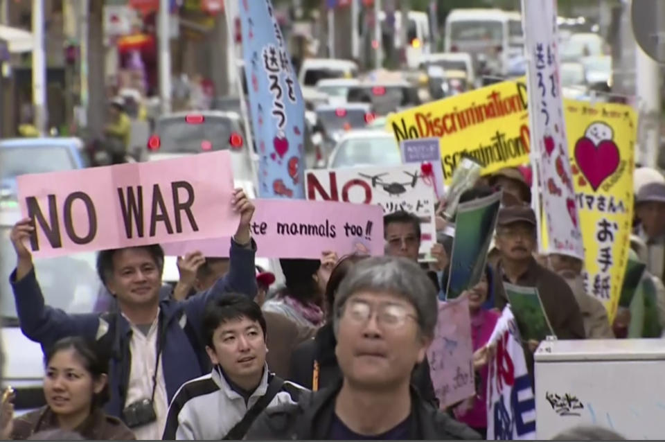 In this video image taken from AP video, protesters march against the relocation plan of the US base in Naha, OKinawa prefecture, Feb. 11, 2014. Several hundred people rallied Tuesday against a contentious plan to relocate a U.S. military base to another site on Okinawa ahead of U.S. Ambassador Caroline Kennedy's visit to the southern Japanese island. (AP Photo via AP video)