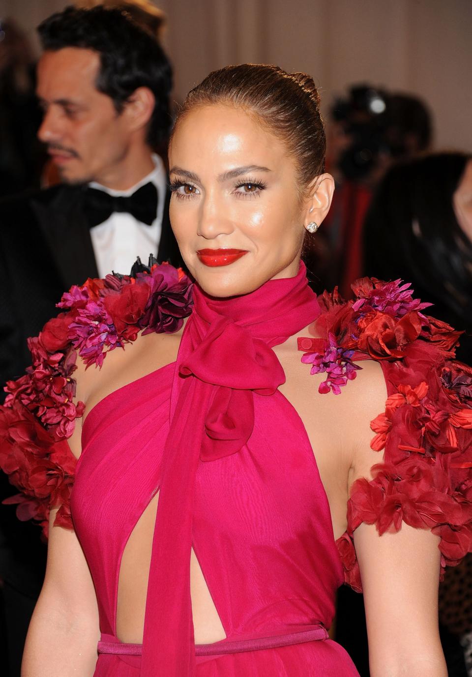 Jennifer Lopez wearing a plunging gown with a bow at the neck and floral embellishments on the shoulders