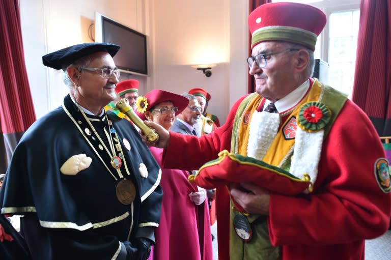 Jean Traon (R) is the co-grand master of Ferte-Mace's tripe fraternity, which inducts its new members at a ceremony with a tap of a bone on the right shoulder