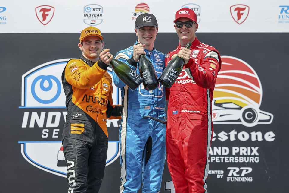 FILE - Team Penske driver Josef Newgarden, center, celebrates his first place finish along with second place finisher Arrow McLaren driver Pato O'Ward of Mexico, left, and third place finisher Team Penske driver Scott McLaughlin of New Zealand in the IndyCar Grand Prix of St. Petersburg auto race, Sunday, March 10, 2024, in St. Petersburg, Fla. Team Penske suffered a humiliating disqualification Wednesday, April 24, when reigning Indianapolis 500 winner Josef Newgarden was stripped of his victory in the season-opening race for manipulating his push-to-pass system. Penske teammate Scott McLaughlin, who finished third in the opener on the downtown streets of St. Petersburg, Florida, was also disqualified. (AP Photo/Mike Carlson)