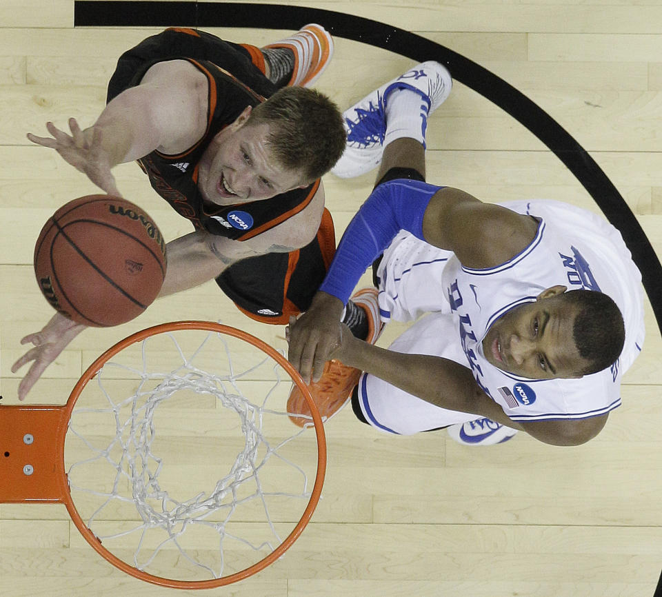 Mercer forward Jakob Gollon (20) shoots over Duke forward Jabari Parker (1) during the first half of an NCAA college basketball second-round game, Friday, March 21, 2014, in Raleigh, N.C. (AP Photo/Chuck Burton)